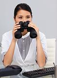 Serious young Businesswoman using binoculars 