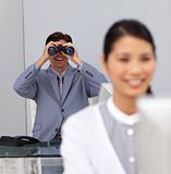Smiling businessman using binoculars 