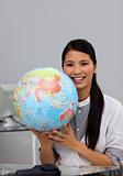 Confident asian businesswoman holding terrestrial globe