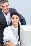 Smiling businesswoman and her manager working at a computer