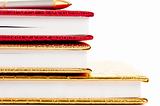 Golden and red notebooks with silver pen