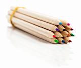 many colored pencils in row over white background