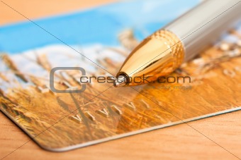 golden pen with credit card