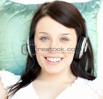 Young woman listening music lying on a sofa 