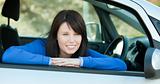 Charming teen girl smiling at the camera sitting in her car