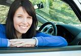 Happy teen girl smiling at the camera sitting in her car
