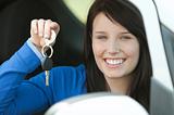 Brunette teen girl sitting in her car holding keys