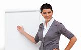 Confident female executive pointing at a board 