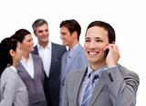 Handsome businessman on phone standing apart from his team