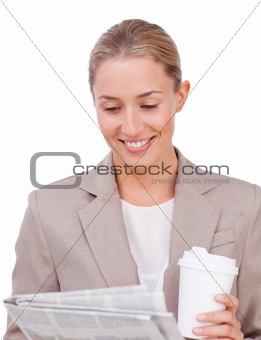 Young businesswoman drinking a coffee reading a newspaper 