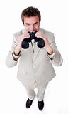 Smiling businessman using a pair of binoculars 