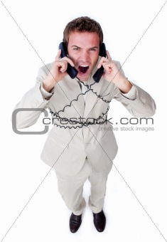 Angry businessman tangle up in phone wires 
