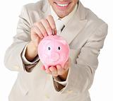 Close-up of a businessman saving money in a piggy-bank 