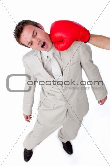 Attractive businessman being hit with a boxing glove 