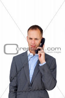 Frustrated businessman tangled up in phone wires 