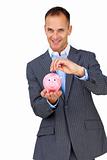 Confident businessman saving money in a piggybank 