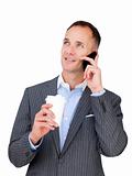 Charming businessman on phone holding a drinking cup 