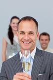 Successful businessman holding Champagne with his team 