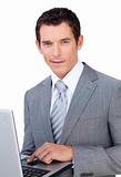 Charismatic young businessman using a laptop