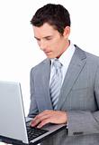 Concentrated businessman using a laptop 