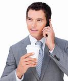 Young businessman on phone holding a drinking cup 