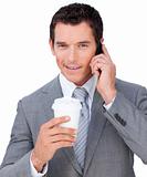 Self-assured businessman on phone holding a drinking cup 