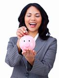 Laughing businesswoman saving money in a piggybank 