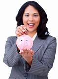 Self-assured young businesswoman saving money in a piggybank