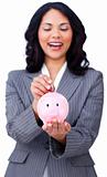 Positive businesswoman saving money in a piggybank 