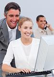 Smiling business team working at a computer