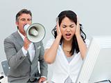 Furious manager shouting through a megaphone in a colleague's ea
