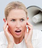 Angry businesswoman listening to a megaphone in the office