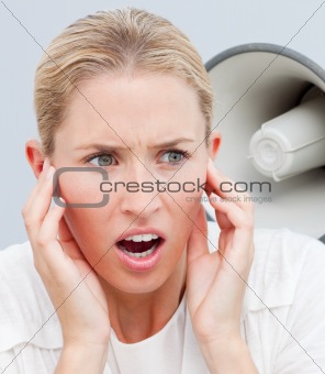 Angry businesswoman listening to a megaphone in the office