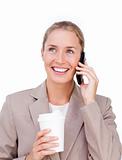 Smiling businesswoman on phone and drinking a coffee