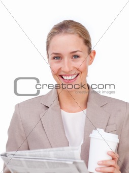 Businesswoman reading a newspaper while drinking a coffee