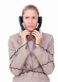 Angry businesswoman tangled up in phone wires 