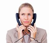 Stressed businesswoman tangled up in phone wires 