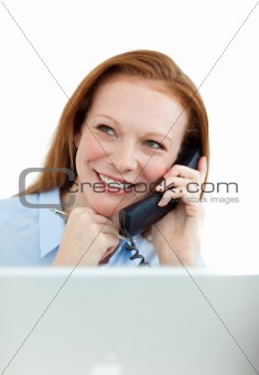 A businesswoman talking on phone at work