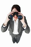 Self-assured businesswoman looking through binoculars 