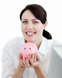 Businesswoman holding a piggybank against a white background