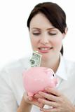 Young businesswoman saving money in a piggybank