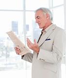 Portrait of a mature manager reading newspaper