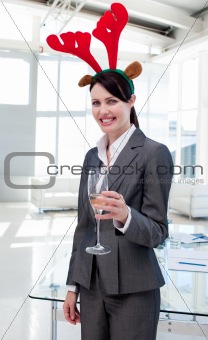 Smiling businesswoman with a novelty Christmas hat toasting with