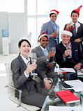 Manager and his team with novelty Christmas hat toasting at a pa