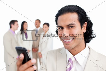 Smiling manager sending a text with a mobile phone with his team