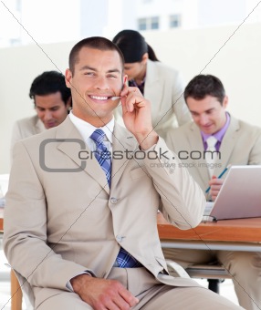 Smiling manager with headset on in front of his team