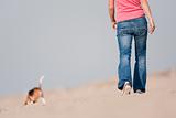 Young woman walking with dog on beach