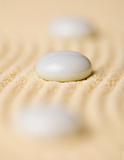 White pebbles on yellow sand closeup