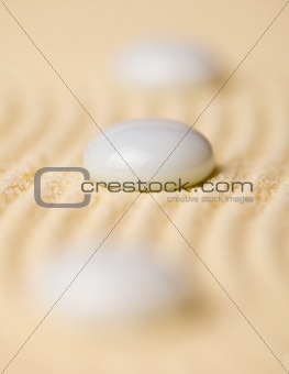 White pebbles on yellow sand closeup