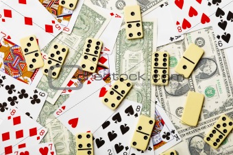 Dominoes are scattered on cards and money